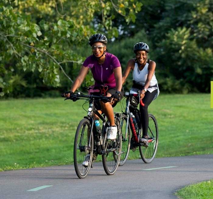 Couple riding bikes on a paved trail.